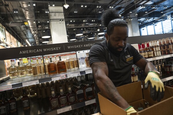 An LCBO employee removes American whiskey from the shelves at the 100 Queens Quay East LCBO outlet in Toronto on Tuesday, March 4, 2025. (Laura Proctor /The Canadian Press via AP)