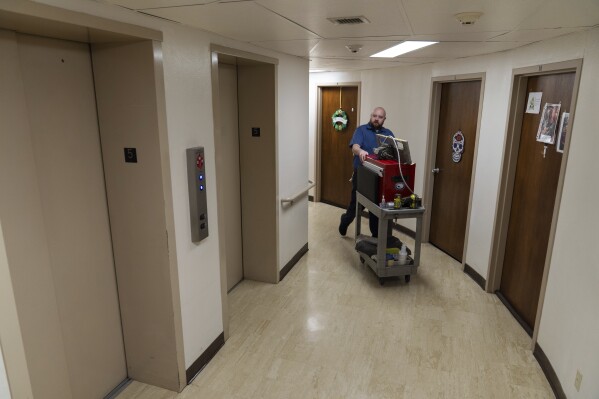 James Richardson walks to the elevator while doing repairs in Smith Tower Apartments on Monday, March 10, 2025, in Vancouver, Wash. (AP Photo/Jenny Kane)