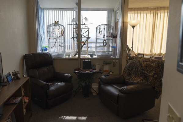 Phyllis Goss' birds sit on a cage inside her studio apartment at Smith Tower Apartments on Monday, March 10, 2025, in Vancouver, Wash. (AP Photo/Jenny Kane)