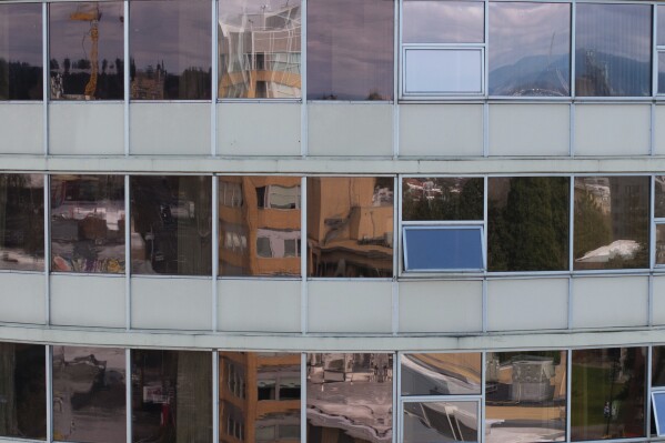 Windows at Smith Tower Apartments reflect the surroundings in Vancouver, Wash., on Monday, March 10, 2025. (AP Photo/Jenny Kane)