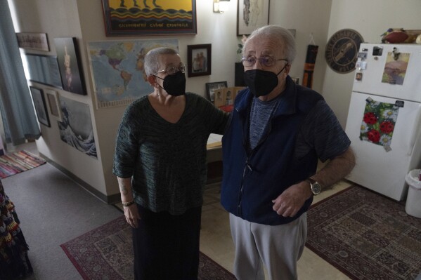 Joan Starr, left, looks at Al Hase as they stand in their apartment at Smith Tower Apartments on Monday, March 10, 2025, in Vancouver, Wash. (AP Photo/Jenny Kane)