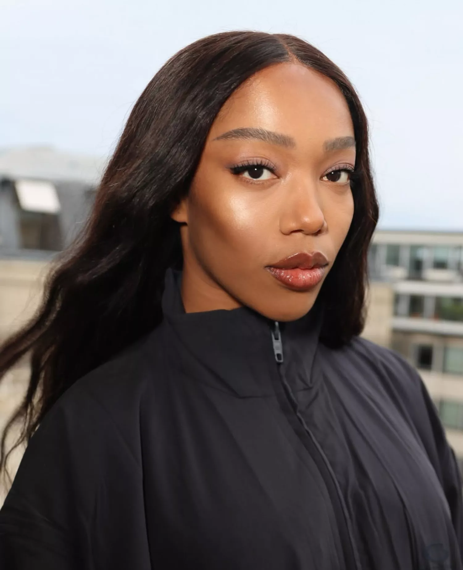 model poses wearing natural nude makeup look with berry lip gloss