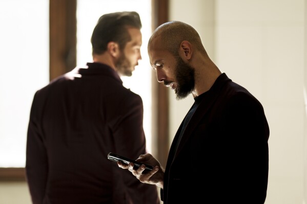 Andrew Tate, right, and his brother Tristan, left, wait at the Court of Appeals building in Bucharest, Romania, Oct. 15, 2024. (AP Photo/Vadim Ghirda, File)